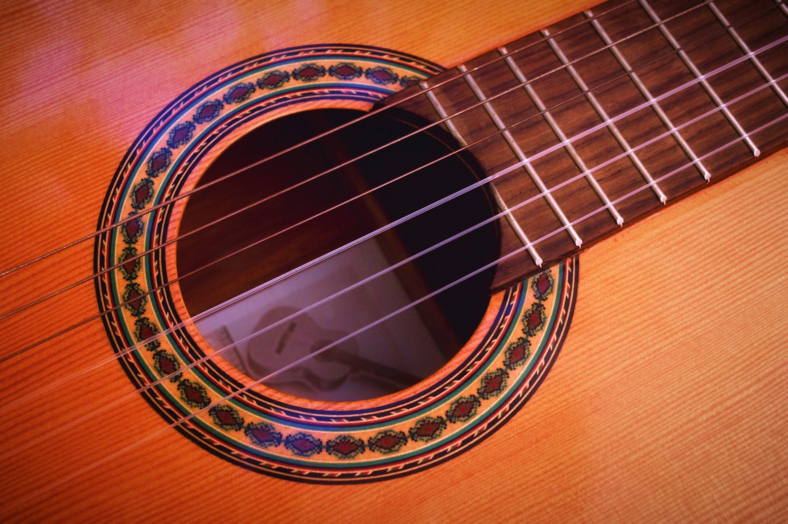 closeup photography of brown acoustic guitar